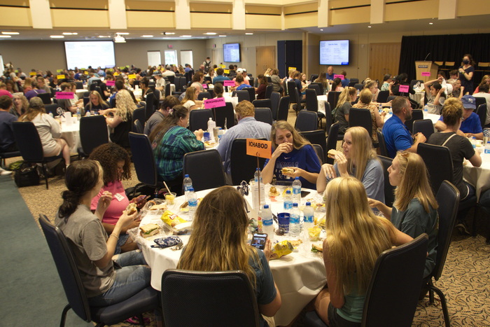 Students sitting at round tables in ballroom